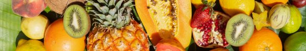 Summer mix of tropical fruits over green leaf